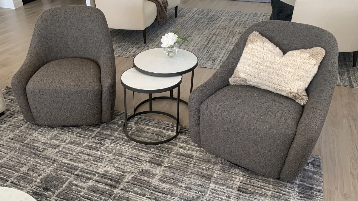 Gray boucle swivel chairs with marble nesting tables