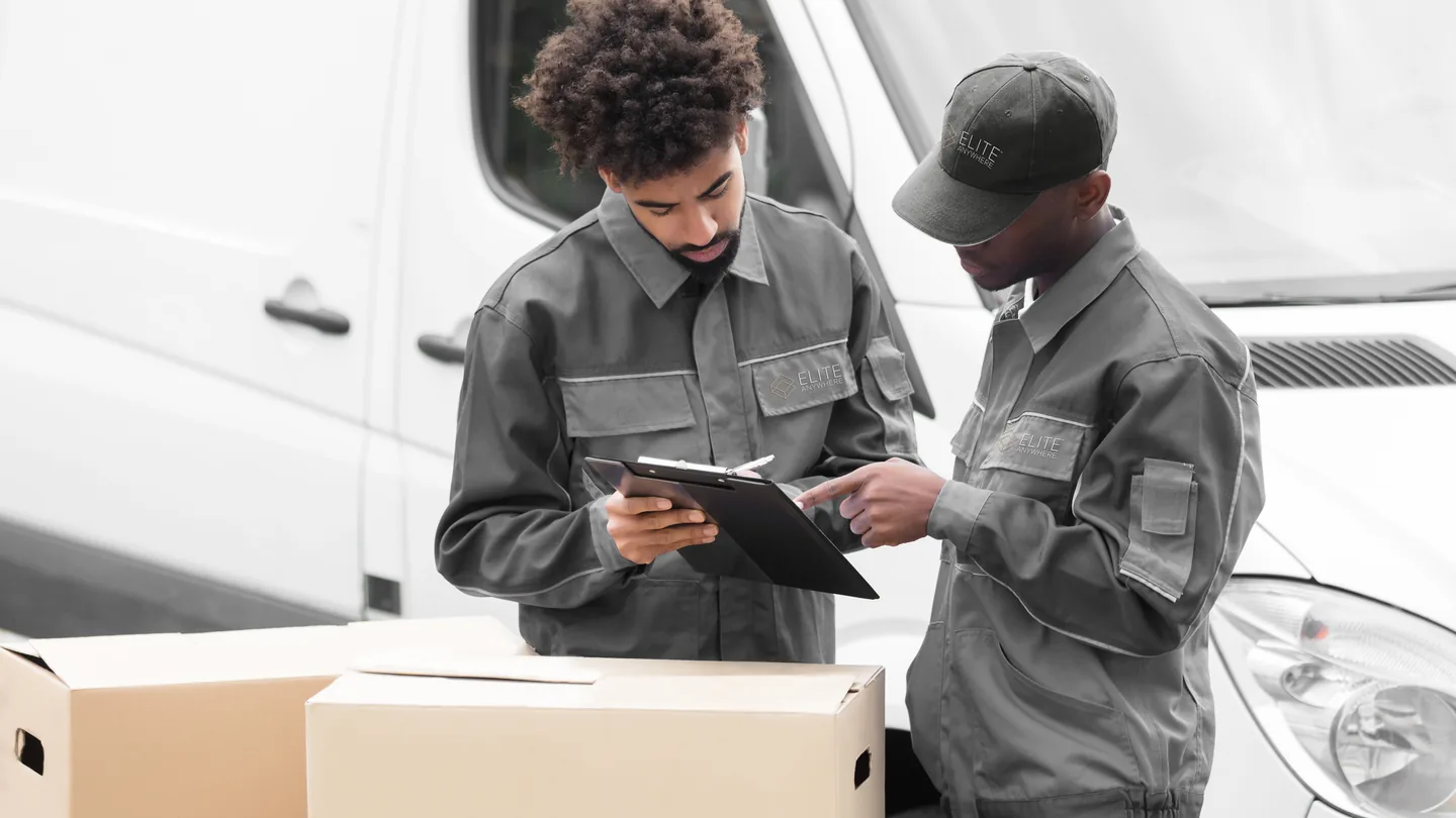 Elite Anywhere operators checking shipment documentation against a clipboard at the van