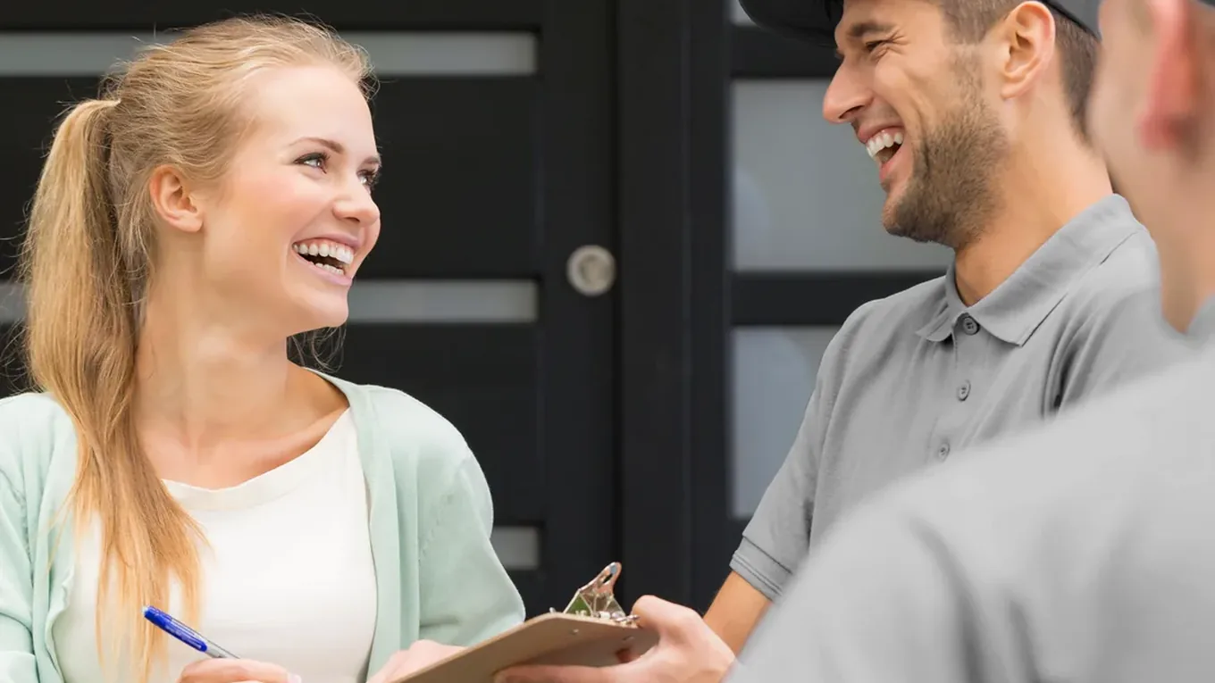 Elite Anywhere driver handing over a branded box at a customer's front door