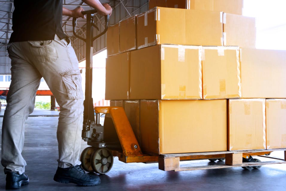 worker pushing warehouse trolley with boxes